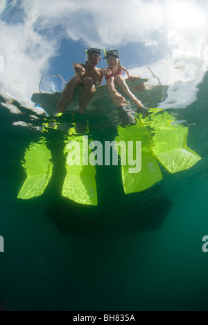 Jeune couple prêt à plonger sur le côté du bateau, Gayana Eco-Resort, Gaya, l'île de Sabah, en Malaisie orientale. Banque D'Images