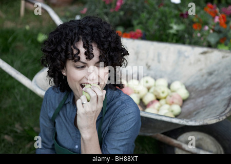 Une femme prenant une bouchée d'une pomme fraîchement cueillie Banque D'Images