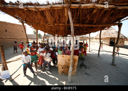 Les enfants à l'école dans le sud de l'Angola, Colui. La salle de classe est à l'air libre sous un toit de chaume de fortune. Banque D'Images