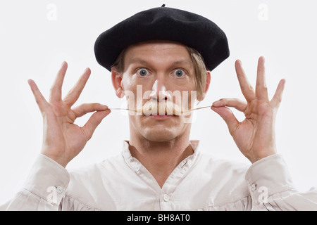 Un homme en costume de tordre sa moustache, portrait Banque D'Images