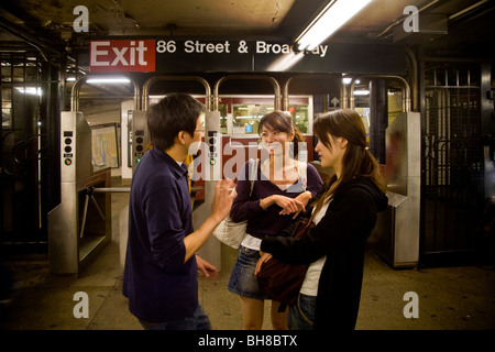 Trois jeunes asiatiques converser à la 86e Street station de métro de la ville, système de transport en commun rapide New York Banque D'Images