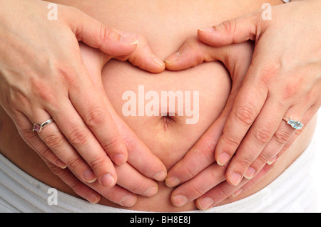 Forme de coeur sur un ventre de femme enceinte Banque D'Images