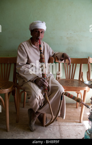 Un vieil homme égyptien fumer un narguilé dans un café du tuyau dans la ville d'al-Qasr, Dakhla Oasis, région ouest du désert du Sahara, l'Egypte. Banque D'Images