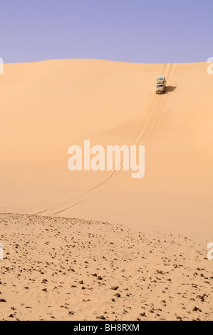 Un désert safari Land cruiser 4x4 Jeep écussons une dune de sable géant dans la grande mer de sable du désert occidental, Sahara Égyptien, l'Egypte. Banque D'Images