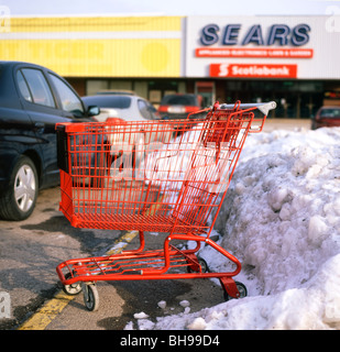 Rouge Panier vide dans un parking enneigé à l'extérieur de l'Ontario Fort Erie magasin Sears Canada Banque D'Images