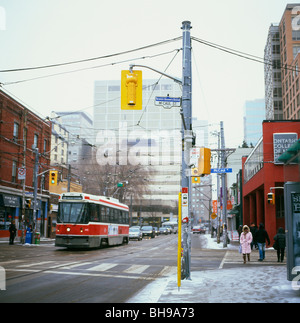 Tramway sur la rue Dundas, près de rue McCaul en hiver avec des trottoirs enneigés et les piétons Toronto, Ontario Canada Banque D'Images