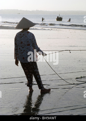 Les FEMMES DU VIETNAM À PARTIR DE LA COOPÉRATIVE DE PÊCHE CASTING NET DANS LA MER PRÈS DE MUI NE Banque D'Images