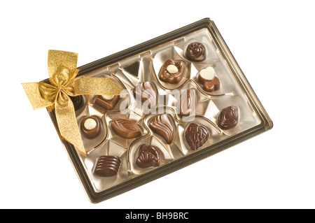 Confiseries au chocolat dans une boîte en or isolé sur fond blanc Banque D'Images