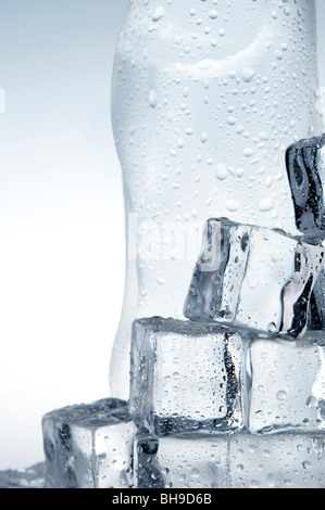 Bouteille d'eau minérale bleu clair et des cubes de glace Banque D'Images