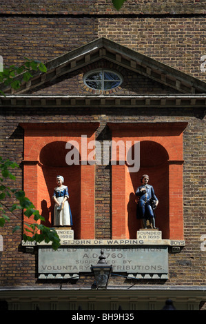 La façade d'un dix-huitième siècle, l'école Saint Jean de Wapping, fondée 1695, érigée en 1760. Deux statues d'enfants. Banque D'Images