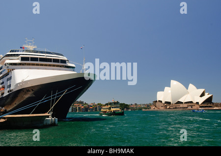 Sydney Opera House Cruise Ship Circular Quay Sydney // SYDNEY, Australie — Un grand navire de croisière, le Volendam, est amarré à Circular Quay, à côté du quartier des Rocks, avec l'Opéra de Sydney en arrière-plan. Un ferry est également visible sur les eaux bleu-vert vibrantes du port. Banque D'Images