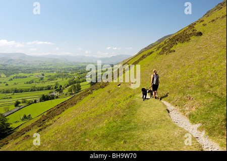 Jeune femme entre chiens en laisse sur les balances ont chuté de flanc Blencathra. Parc National de Lake District, Cumbria, Angleterre. À SW. Banque D'Images