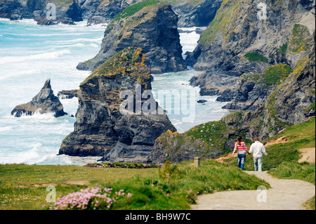 Jeune couple en train de marcher le long du chemin de la côte sud-ouest au nord de la mer vers Newquay des piles de Bedruthan Steps, Cornwall, Angleterre Banque D'Images