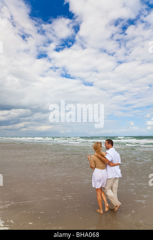 Un jeune homme et femme couple avoir promenade romantique sur une plage Banque D'Images