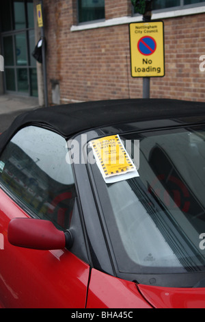 Un ticket de parking sur une voiture garée dans une zone d'attente sur une rue au Royaume-Uni. Banque D'Images