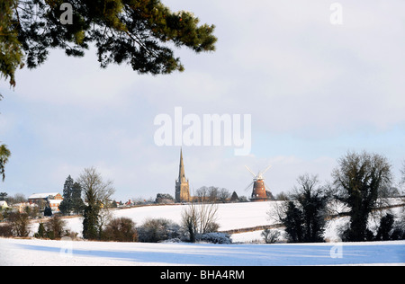 Vue sur la campagne de l'Essex montrant l'église paroissiale de St John et moulin à Thaxted après un hiver neige Banque D'Images