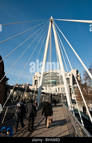 Marcher à travers Hungerford Bridge sur la Tamise à Londres à la gare de Charing Cross Banque D'Images