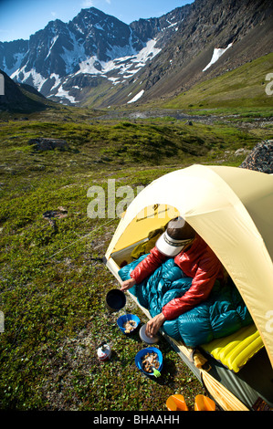 Randonneur prépare un repas du matin au camp sur le sentier des lacs Williwaw Chugach State Park dans près d'Anchorage, Southcentral Alaska Banque D'Images