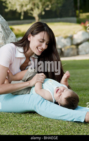 Young woman playing in garden with baby boy Banque D'Images