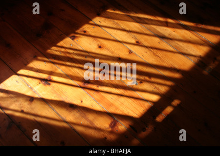 La lumière du soleil tombant sur le plancher ciré en bois, la création d'ombre. Banque D'Images