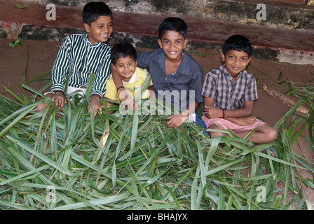 Les enfants qui s'amuse avec des feuilles de coco. Banque D'Images