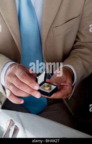 Libre de mains de jeune homme tenant une bague dans une boîte de bijoux Banque D'Images