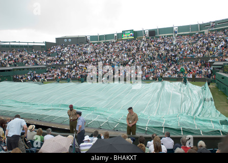 Centre court couvre sont déployés pour couvrir la surface de jeu, de Wimbledon, Royaume-Uni Banque D'Images