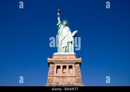 La Statue de la liberté face à l'encontre d'un ciel bleu clair sur une journée ensoleillée avec le socle visible Banque D'Images