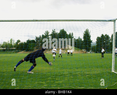 Goalkeepr plongées à son droit d'enregistrer un coup de joueur de champ pendant le préchauffage, Banque D'Images