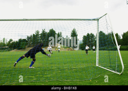 Goalkeepr plongées à son droit d'enregistrer un coup de joueur de champ pendant le préchauffage, Banque D'Images