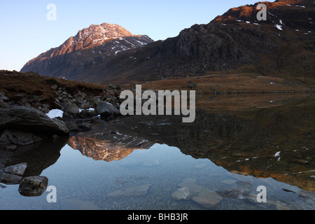 La face ouest de la montagne, un Tryfan en Galles, baigné de lumière du soir et se reflétant dans les eaux de Llyn Idwal Banque D'Images