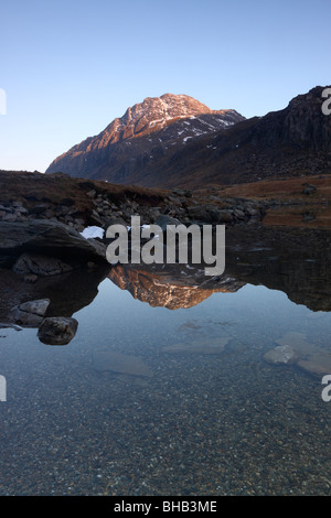 La face ouest de la montagne, un Tryfan en Galles, baigné de lumière du soir et se reflétant dans les eaux de Llyn Idwal Banque D'Images