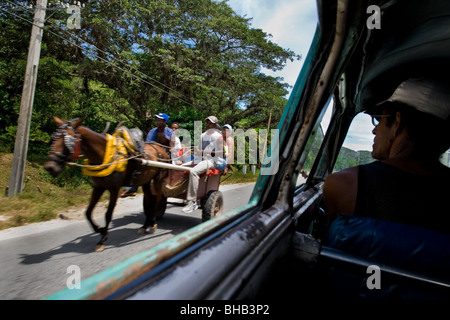 Un chariot à cheval passant contre la voiture sur la route de campagne, près de Santiago de Cuba, Cuba. Banque D'Images