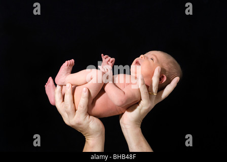 Bébé nouveau-né dans les mains des pères isolés sur Black, âgée de 13 jours Banque D'Images