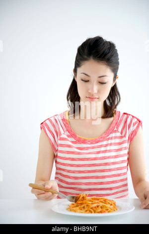 Japon, Osaka Prefecture, young woman eating spaghetti Banque D'Images