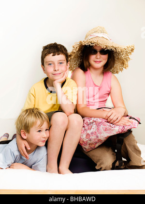 Portrait de 3 enfants assis sur un lit Banque D'Images