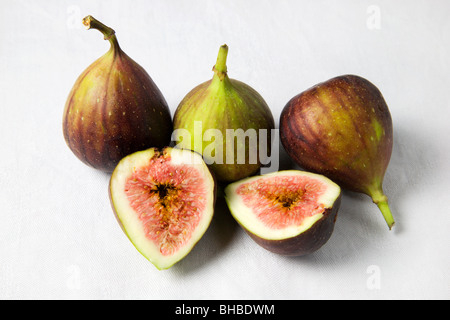 Figues entières et des moitiés sur un fond blanc Banque D'Images