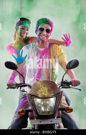 Couple sur une moto couverts avec des couleurs Banque D'Images