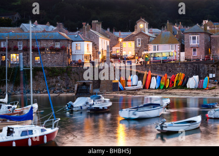 Le crépuscule tombant sur les bateaux se balançant sur la marée dans le port dans l'ancien village de pêcheurs de Mousehole, Cornwall Banque D'Images