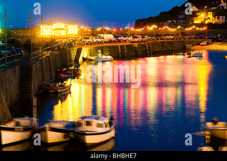 Nuit qui tombe sur le balancement des bateaux sur la marée dans le port dans l'ancien village de pêcheurs de Mousehole, Cornwall Banque D'Images