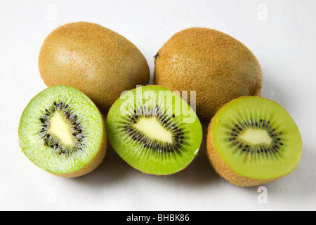 Ensemble et moitié Kiwifruits sur fond blanc Banque D'Images