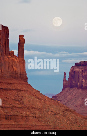 USA, Utah, Monument Valley Navajo Tribal Park. Au cours de la lune Mitten Buttes au coucher du soleil. Banque D'Images