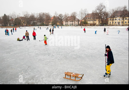 Les enfants ont plaisir à jouer au hockey sur glace sur le lac gelé près de Palais Nymphenburg à Munich. L'Allemagne. Banque D'Images