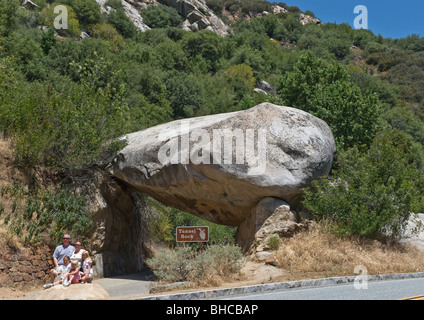 Énorme rocher tombé de la falaise et la montagne érodée située au-dessus de la roche solide formant entrée en forme sur route de montagne. Banque D'Images