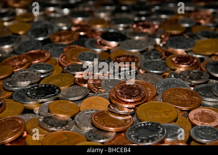 Table pleine de changement lâche en livres sterling sur table sur un fond noir Banque D'Images