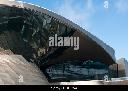 L'architecture moderne de BMW Welt à Munich avec une scène couverte de neige se reflétant dans ses fenêtres. L'Allemagne. Banque D'Images