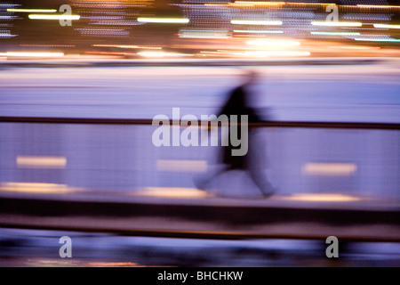 Personne qui marche sur une passerelle le long du lac Tjornin (blurred motion). Le centre de Reykjavik en Islande Banque D'Images