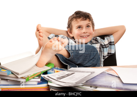 Portrait d'un écolier pieds nus avec ses pieds sur son bureau, attendant pour les vacances à venir Banque D'Images