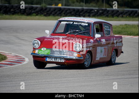 Ford Anglia rouge classic car racing dans un rassemblement en Espagne. Banque D'Images