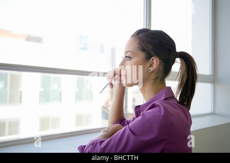 Femme d'affaires en regardant par la fenêtre Banque D'Images